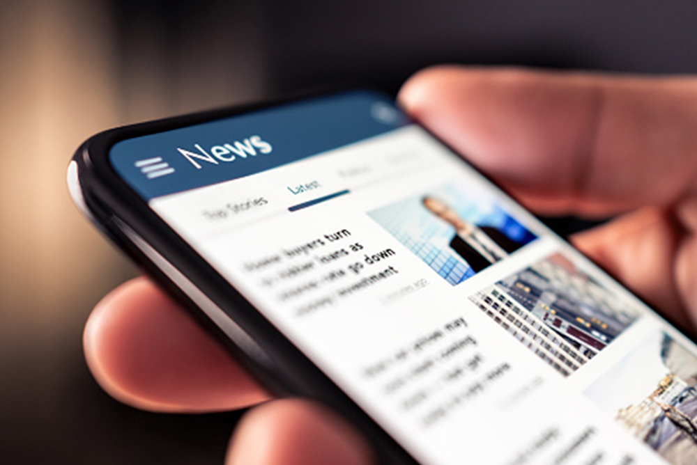 Person reading project news on a smartphone screen symbolizing updates and developments from the EU BIO4COAT project on sustainable biobased coatings.